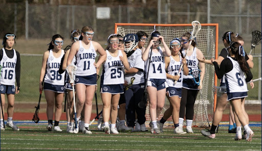 The Girls Lacrosse team celebrates after scoring a goal.
