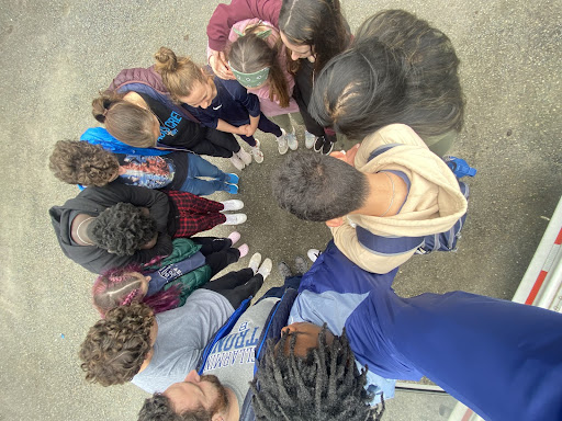 The Magis leaders gather in a group to pray over the retreat.

