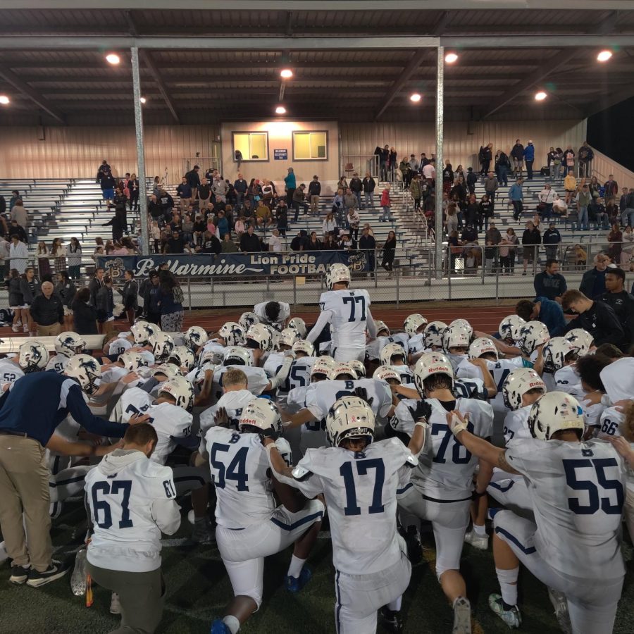 Senior Mac Fortino leads the Lions in the post game prayer. 