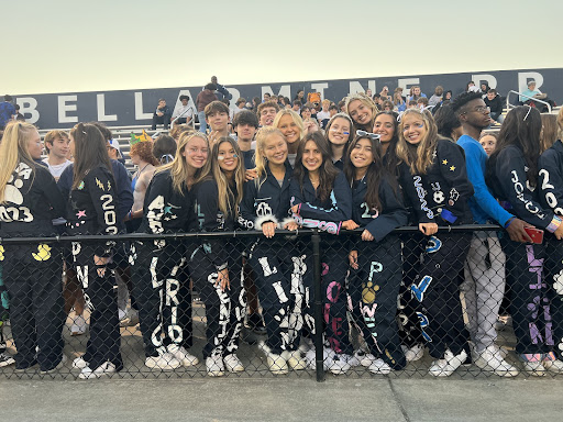 Seniors cheer at the Homecoming football game in their jumpsuits.