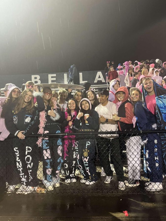 The Lions student section celebrates a win on senior night in the pouring rain.