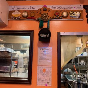  A banner and cap celebrating Bhanchha Ghar’s fourth year
winning the Momo Crawl hang over their kitchen.
