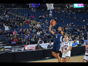Kiara Stone drives to the hoop, about to score.