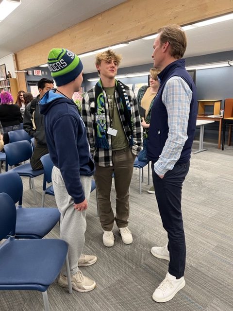 Journalists Levi Coovert and Drew Albaugh talk to Hugh Weber after the press conference.