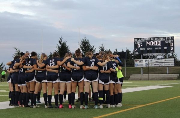 The soccer team gathers on the field. 